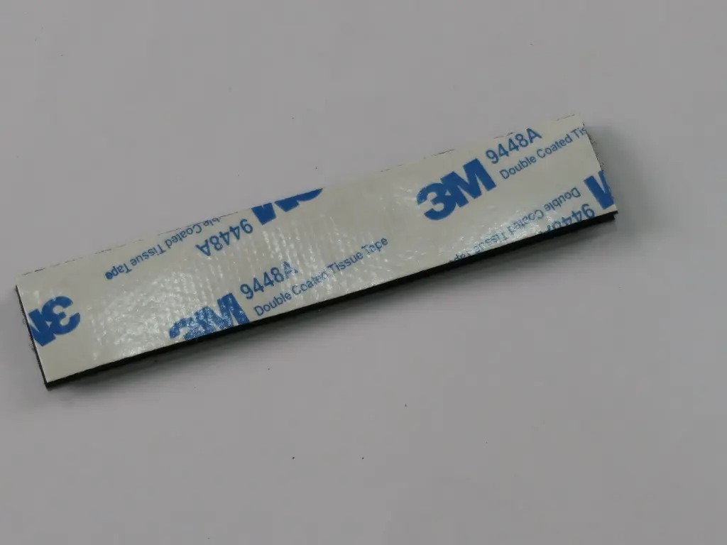 Fixador adesivo para o pacote de pilhas